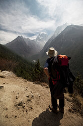 Ein einsamer männlicher Trekker blickt vom Weg zu den fernen Gipfeln um die Amadablam in Nepal. - AURF01964