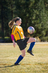 Ein Mädchen spielt Fußball in Uniform. - AURF01989