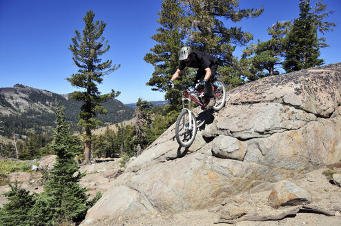 Ein Mountainbiker fährt im Sommer im Kirkwood Mountain Resort, Kalifornien, einen technischen Felsabschnitt hinunter. - AURF02000