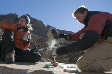 Ein Mann und eine Frau kochen Wasser auf einem Campingkocher oberhalb der Baumgrenze bei Telluride, Colorado. - AURF02035