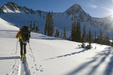 A man backcountry skiing below the Pfeifferhorn in Lone Peak Wilderness, Salt Lake City, Utah. - AURF02042