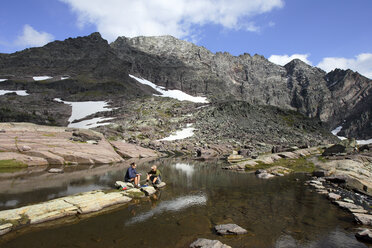 Ein Mann und eine Frau filtern Wasser im Glacier National Park, Montana. - AURF02053