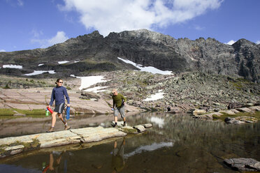 A man and woman filter water in Glacier National Park, Montana. - AURF02054