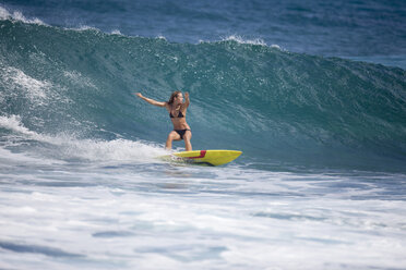 A surfer girl surfing at Rocky Point, on the north shore of Oahu, Hawaii. - AURF02063