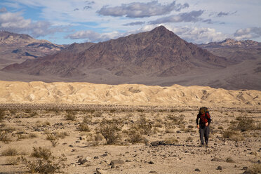 Ein junger Mann wandert mit dem Rucksack durch die Confidence Hills im Death Valley Nation Park, Kalifornien. - AURF02108
