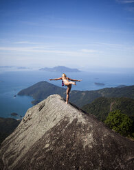 A woman practices yoga on top of a cliff - AURF02119