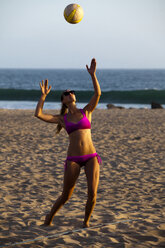 Eine athletische und durchtrainierte Beachvolleyballspielerin bereitet einen Aufschlag während eines Spiels in Ventura, Kalifornien, vor. - AURF02153