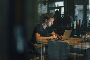 Man sitting in office, working late in his start-up company - GUSF01213