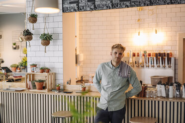 Junger Mann am Tresen in seinem Café, Porträt - GUSF01232