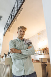 Junger Mann arbeitet in seinem Start-up-Café, Porträt - GUSF01238