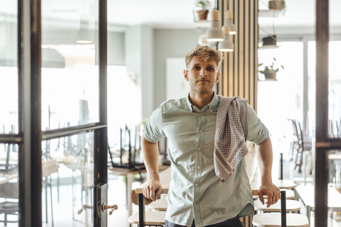 Junger Mann arbeitet in seinem Start-up-Café, Porträt, lizenzfreies Stockfoto