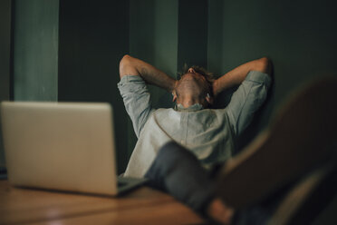 Tired man sitting in office, working late in his start-up company - GUSF01276