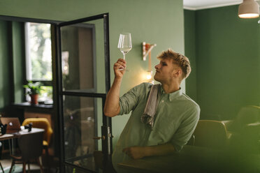 Junger Geschäftsinhaber prüft Weinglas in seinem Restaurant - GUSF01282