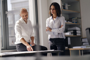 Two architects working in office, discussing blueprints - KNSF04373