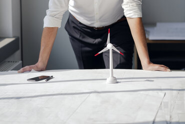 Ingenieur bei der Arbeit in seinem Büro mit dem Modell eines Flügelrads auf seinem Schreibtisch - KNSF04379