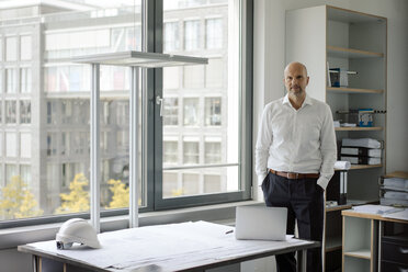 Erfolgreicher Ingenieur steht in seinem Büro - KNSF04422