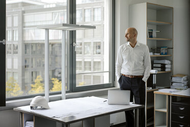 Erfolgreicher Ingenieur steht in seinem Büro - KNSF04423