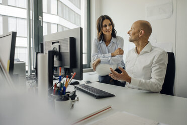 Businessman and woman working together in office - KNSF04441