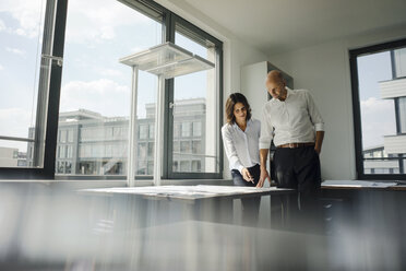 Two architects working in office, discussing blueprints - KNSF04453