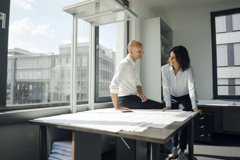 Zwei Architekten arbeiten in einem Büro und besprechen Entwürfe, lizenzfreies Stockfoto