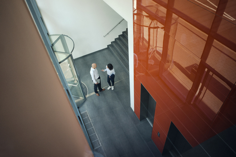 Business people talking in front of elevator stock photo