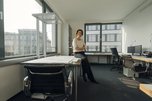 Erfolgreiche Geschäftsfrau sitzt in ihrem Büro am Schreibtisch - KNSF04554