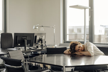 Tired businesswoman sleeping on her desk - KNSF04567