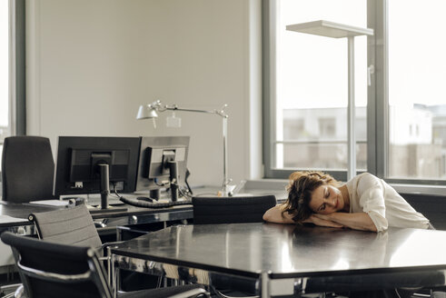 Müde Geschäftsfrau schläft auf ihrem Schreibtisch - KNSF04567