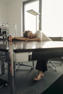 Müde Geschäftsfrau schläft auf ihrem Schreibtisch - KNSF04569