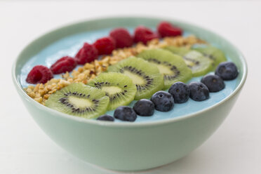 Smoothie-Bowl mit Heidelbeeren, Himbeeren, Kiwi und gehackten Haselnüssen - JUNF01101