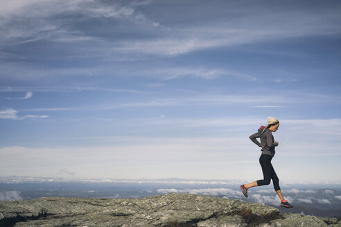 Frau beim Trailrunning auf einem felsigen Bergrücken in Neuengland. - AURF02203