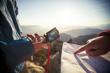 Zwei Männer benutzen eine Papierkarte und einen Kompass, um beim Wandern in der North Cascade Mountain Range zu navigieren. - AURF02248