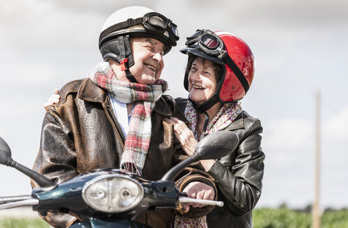 Glückliches älteres Paar fährt Motorroller - UUF14924