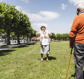 Seniorin beobachtet ältere Dame beim Spielen mit einem Hoola Hoop - UUF14952