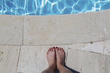 Woman's feet at poolside - JUNF01130