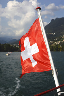 Schweiz, wehende Schweizer Flagge von Boot auf dem Luganer See, Nahaufnahme - JTF01051