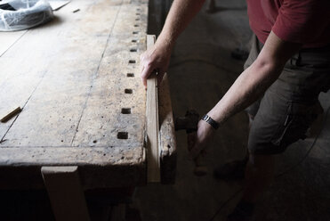Nahaufnahme eines Zimmermanns, der ein Stück Holz in der Werkstatt einspannt - PSIF00059