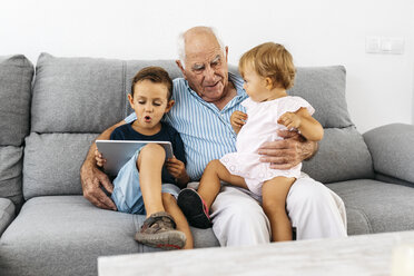 Portrait of grandfather spending time with his grandson and granddaughter at home - JRFF01800