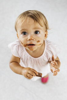 Porträt eines kleinen Mädchens, das einen Schokoladenkeks isst - JRFF01813