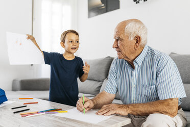Großvater und Enkel zeichnen mit Buntstiften im Wohnzimmer - JRFF01818