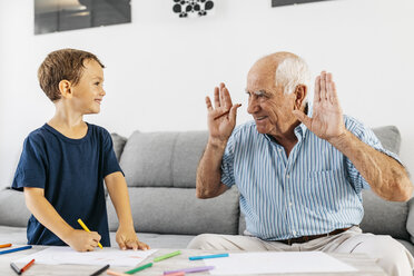 Grandfather and grandson drawing with coloured pencils at home - JRFF01820