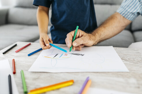 Grandfather and grandson drawing with coloured pencils at home, partial view - JRFF01824