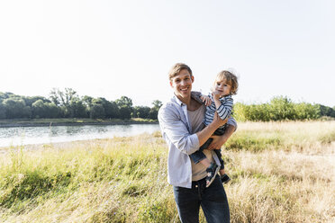 Vater und Sohn haben an einem schönen Sommertag Spaß am Fluss - UUF14959