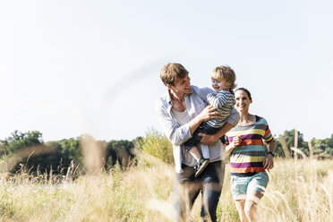 Glückliche Familie bei einem Spaziergang am Flussufer an einem schönen Sommertag - UUF14967