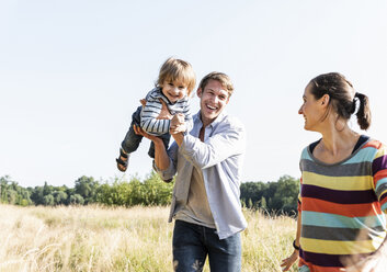 Happy family walking at the riverside on a beautiful summer day - UUF14969