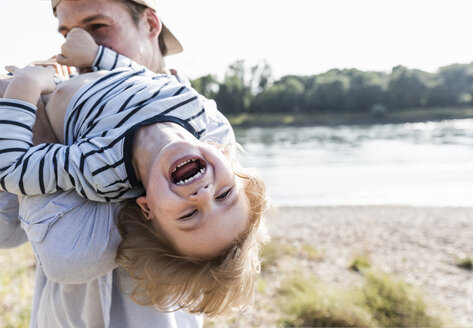 Father and son having fun at the riverside - UUF14984