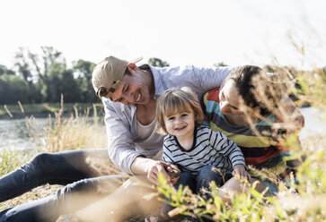 Happy family having fun at the riverside on a beautiful summer day - UUF14987