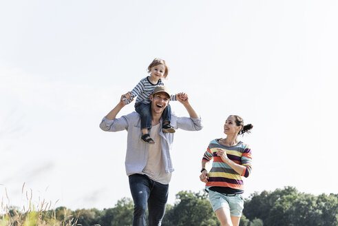 Glückliche Familie bei einem Spaziergang am Flussufer an einem schönen Sommertag - UUF14995