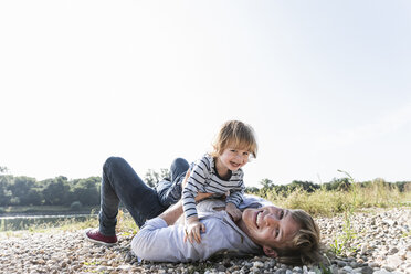 Father and son having fun at the riverside - UUF14999