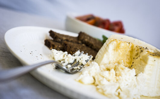 Ricotta-Käse mit Honig und Schwarzbrot auf einem Teller - RAMAF00012